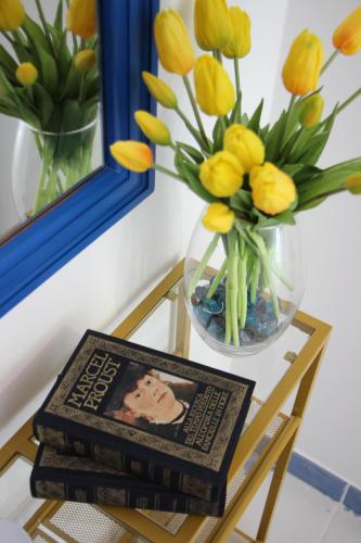a table with a vase of flowers and a picture at Villa Loreta in Ischia