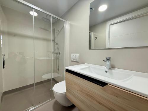 a bathroom with a sink and a toilet and a mirror at PADRÓN PLAZA Lofts, Centro in Padrón