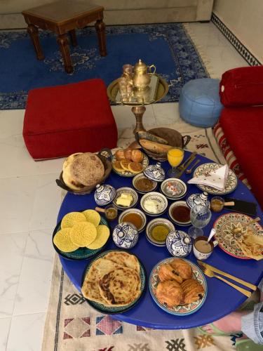 a table with many plates of food on it at Riad Rkiya with Courtyard in Tiznit