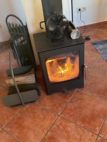 a stove in a room with a chair and a fire at natuurleev in Hanerau-Hademarschen