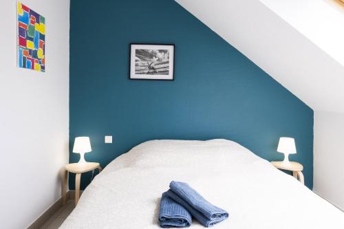 a bedroom with a bed with a blue wall at gîte de l'artiste Segré ? T2 confort ? centre ? 2 lits in Segré