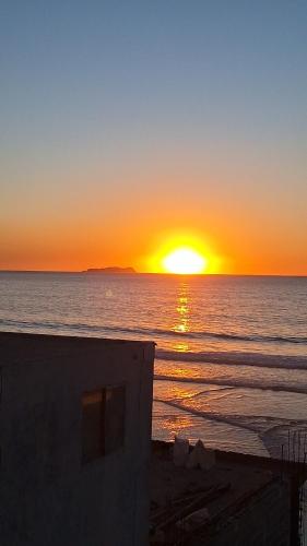 a sunset on the beach with the sun setting at VIP bed private partition in Ajman 