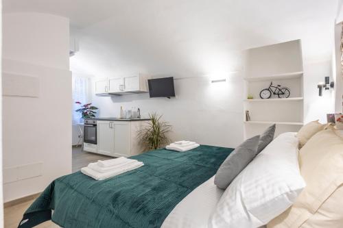 a living room with a large bed with a green blanket at Torre delle Rondini in Isolabona