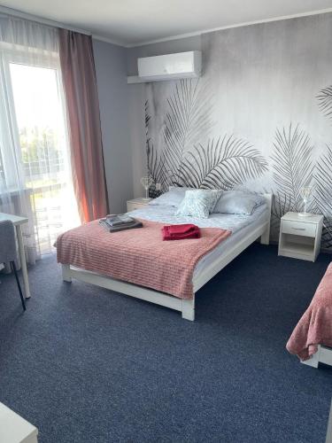 a bedroom with a bed and a large window at Dom Gościnny "Zawiśle" in Włocławek