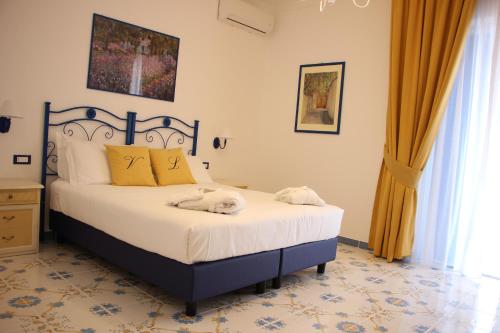 a bedroom with a large bed with yellow pillows at Villa Loreta in Ischia