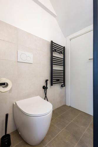 a bathroom with a white toilet in a room at Torre delle Rondini in Isolabona