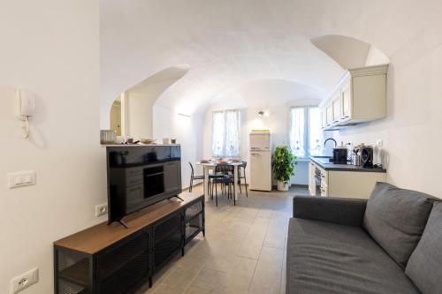 a living room with a couch and a kitchen at Torre delle Rondini in Isolabona