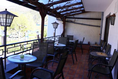 a restaurant with tables and chairs and a large window at Weinhaus Hirschen Bruttig in Bruttig-Fankel