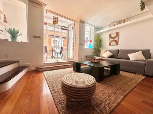 ein Wohnzimmer mit Sofa und Tisch in der Unterkunft Atuaire Home Encanto urbano rozando la Catedral con Parking Incluido in Burgos