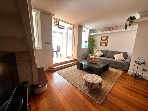 ein Wohnzimmer mit einer Couch und einem Couchtisch in der Unterkunft Atuaire Home Encanto urbano rozando la Catedral con Parking Incluido in Burgos