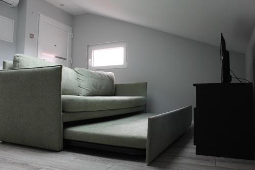 a living room with a couch and a television at Apartamentos do Parque in Vila Real