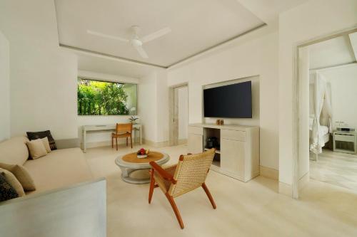 a living room with a couch and a tv at COMO Uma Ubud in Ubud
