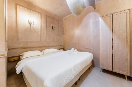 - une chambre avec un grand lit blanc et une armoire dans l'établissement Grand loft au Style Raffine - Paris 13 - 3P, à Paris