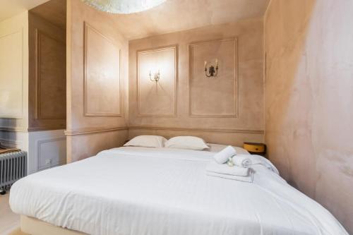 une chambre avec un grand lit blanc avec des serviettes dessus dans l'établissement Grand loft au Style Raffine - Paris 13 - 3P, à Paris