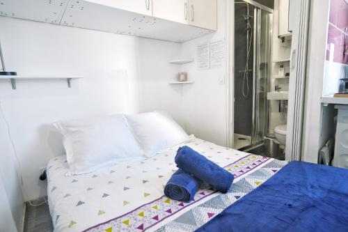 - un lit avec une serviette bleue dans l'établissement Chess Flat - Paris Grands Boulevards, à Paris