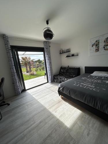 - une chambre avec un lit et une grande porte coulissante en verre dans l'établissement Maison moderne au calme proche Montauban Toulouse, à Orgueil