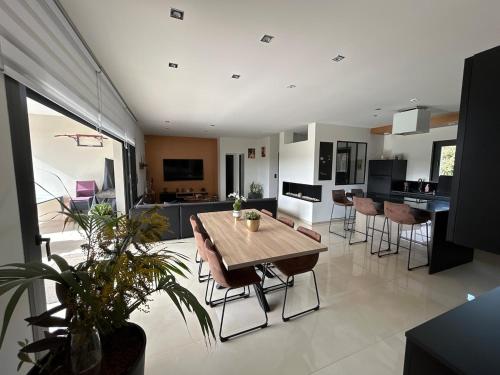une cuisine et une salle à manger avec une table et des chaises dans l'établissement Maison moderne au calme proche Montauban Toulouse, à Orgueil