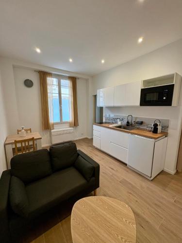 un salon avec un canapé et une cuisine dans l'établissement App neuf 1 chambre près du centre et plages, à Antibes