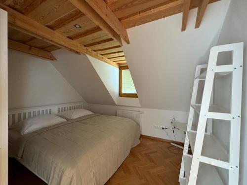 a bedroom with a bed and a ladder in a attic at Kralova Apartment in Modra in Modra