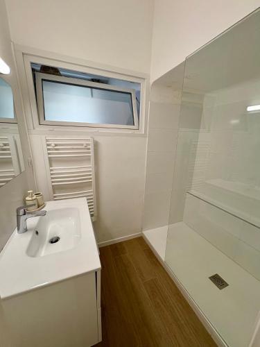 une salle de bain blanche avec un lavabo et une douche dans l'établissement App neuf 1 chambre près du centre et plages, à Antibes