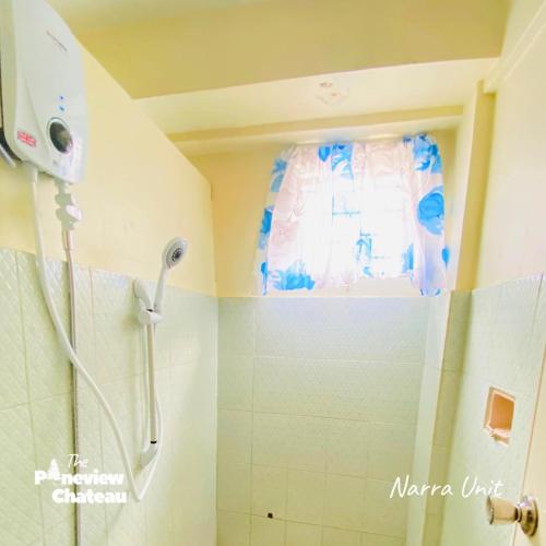 a shower in a bathroom with a window at 2-BR Narra Unit by The Pineview Chateau in Baguio