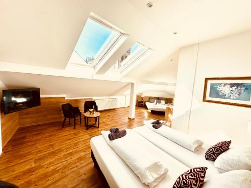 a living room with two beds and a tv at Hotel am Markt Bacharach in Bacharach