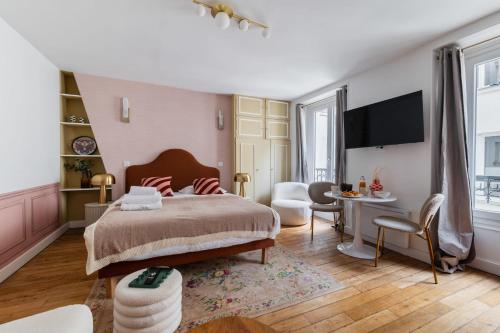 une chambre avec un grand lit et un salon dans l'établissement Grand studio refait a neuf Paris 16 - 4P, à Paris