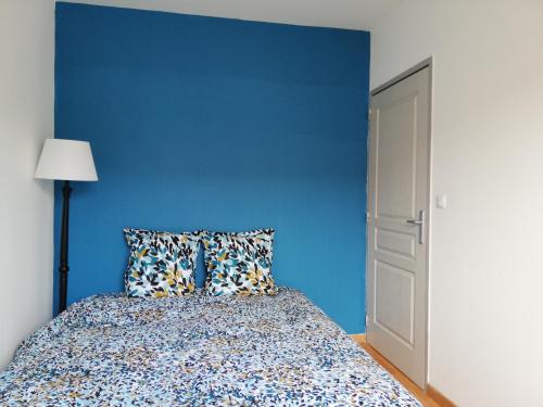 a blue bedroom with a bed and a blue wall at Gîte d'Anouck au coeur d'Oudon proche baignade in Oudon