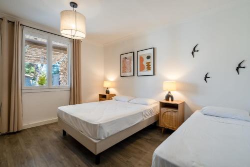 une chambre avec deux lits et une fenêtre dans l'établissement Small stone mas T2 in a tourist residence, à La Roque-sur-Pernes