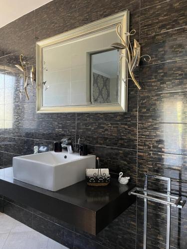 a bathroom with a white sink and a mirror at SeaViewPeramou in Elevtheraí