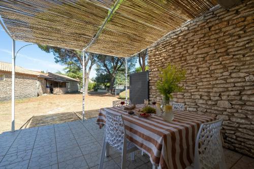 une table avec un tissu de table rayé sur une terrasse dans l'établissement Nice provencal cottage in a tourist residence, à La Roque-sur-Pernes