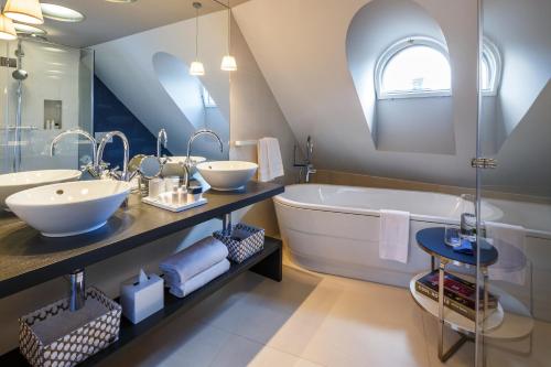 La salle de bains est pourvue d'une grande baignoire, de 2 lavabos et d'un grand miroir. dans l'établissement Hotel Seehof, à Zurich