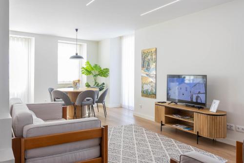 ヴィアナ・ド・カステロにあるMexia Galvão city centerのソファ、テレビ、テーブルのあるリビングルーム