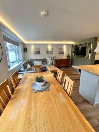 a living room with a large wooden table and chairs at Holiday Bungalow in Arnside in Arnside