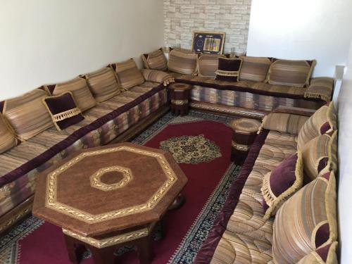 a room with a couch and a table and chairs at Appartement situé en plein cœur d'Agadir in Agadir