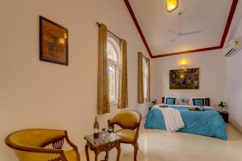 Un dormitorio con una cama, una silla y una mesa. en 2BHK Private Pool Villa, JAQK Holidays, en Arpora