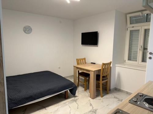 ノヴァリャにあるMimis Apartmentsのテーブル、ベッド、テーブル、椅子が備わる客室です。