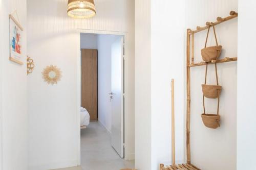 un couloir aux murs blancs et un couloir avec des paniers sur le mur dans l'établissement #35 Suite Carlone 5min from the beach AC & Terrace, à Nice