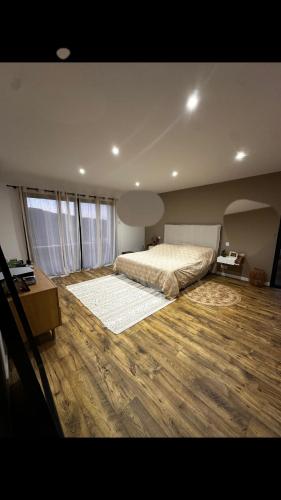 - une grande chambre avec un lit et du parquet dans l'établissement Magnifique Villa avec piscine et jacuzzi, à Alata