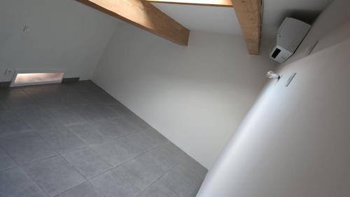 Cette chambre mansardée est dotée de murs blancs et de carrelage. dans l'établissement Grand appartement, à Béziers