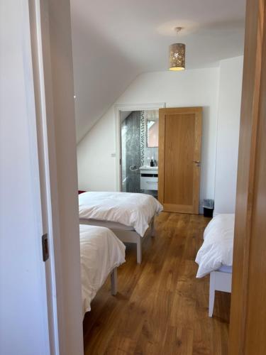 a room with two beds and a bathroom at Lough Key Luxury Riverfront Apartment in Cootehall