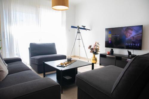 a living room with a couch and a tv at Thalia's Holiday Apartment in Tala Chorio in Tala