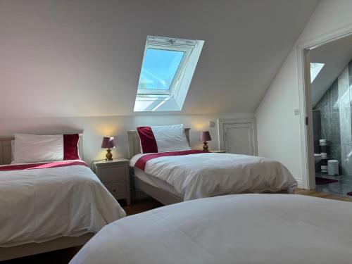 a bedroom with two beds and a window at Lough Key Luxury Riverfront Apartment in Cootehall