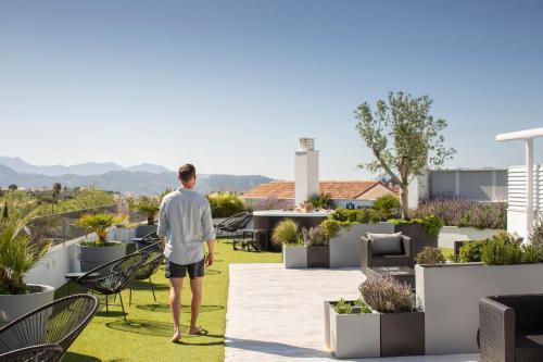 a man standing on the roof of a house with plants at Apartamentos Martalia Arenal in Ronda