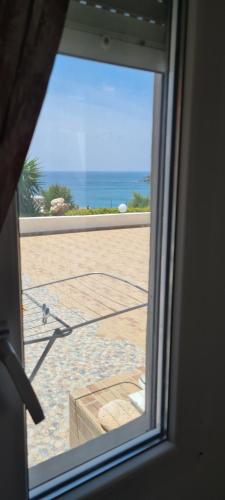 an open window with a view of the beach at Avgerinou Studios in Paliochori