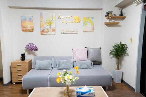 a living room with a couch and a table at 6th floor 602 with elevator, 700 meters walk from Nishi-Shinjuku Gochome 4 minutes to Shinjuku, 75 square meters plus 30 square meters of large balcony in Tokyo