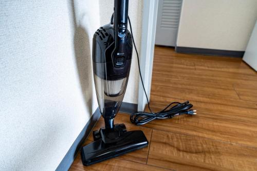 a black hair dryer on the floor next to a wall at 6th floor 602 with elevator, 700 meters walk from Nishi-Shinjuku Gochome 4 minutes to Shinjuku, 75 square meters plus 30 square meters of large balcony in Tokyo