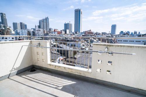 a balcony with a view of the city at 6th floor 602 with elevator, 700 meters walk from Nishi-Shinjuku Gochome 4 minutes to Shinjuku, 75 square meters plus 30 square meters of large balcony in Tokyo
