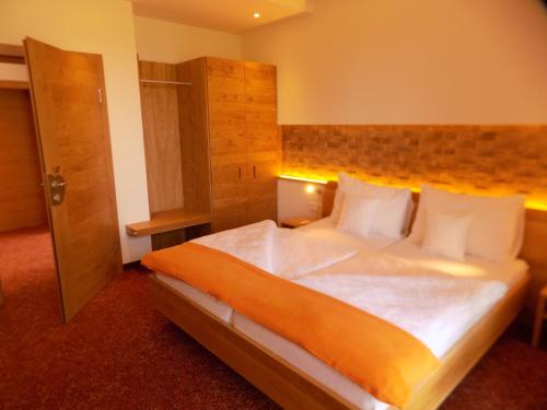 sypialnia z dużym łóżkiem z białą pościelą i poduszkami w obiekcie Mostlandhof w mieście Purgstall