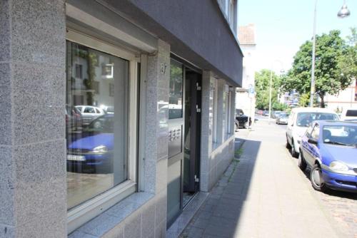 a window of a building with cars parked on a street at City Apartment in Cologne